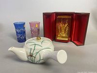 Blue and pink KAGAMI Edo Kiriko crystal sake glasses with KORANSHA porcelain kyusu teapot and lucite gold crown paperweight in red case