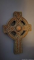 Front view of the cast stone Celtic cross showing detailed knotwork and iron/chromium oxide patina finish.