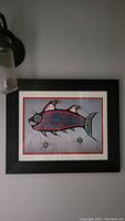 Full view of the Demon Fish print framed and hung on a wall.
