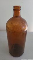 Front view of amber glass Javex bottle showing embossed text with brand name and volume