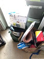 Overview of the lot showing the coffee maker box, fan, lightbulbs box, dental care items and packing materials.