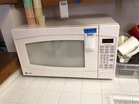 Full view of the GE Profile white microwave oven showing door and size