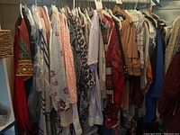 Wide view of women's clothing on hangers with various colors and patterns, size XL-18.