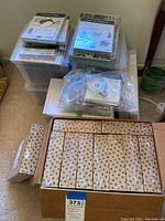 Multiple sealed Stampin Up card kit boxes arranged in a cardboard box with several stamp sets and dies visible on top in clear packages.