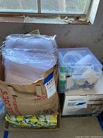 Bag filled with clear plastic sheets or craft bags, stacked on a box with a floral pattern.