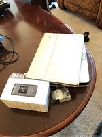 White Speck tablet with cover on a wooden table next to a box and remote control
