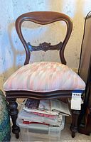 Front angle view of the vintage balloon back wooden chair with padded fabric seat.