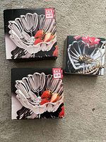 Two boxed tulip-shaped glass bowls and one small clear glass dish pictured on carpet