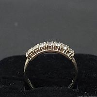 Front view showing seven round diamonds set along the top of the band