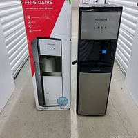 Photo showing full water dispenser with original box beside it, front view.