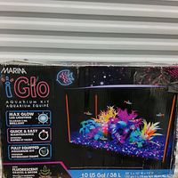 Photo of packaging box for Marina iGlo Aquarium Kit showing aquarium with LED lighting, fluorescent gravel and plants, and product features outlined on box front