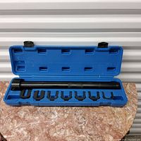 Inner tie rod tool set open in blue plastic case, showing long handle and eight fork attachments
