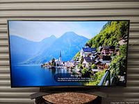 Front view of powered-on LG 55UH7700-UB TV displaying scenic image with 'No Signal' message