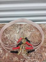 Two speaker cables laid out on a marble surface showing the full length with red and black color-coded gold-plated banana plugs at each end.