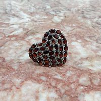 Front view of the heart-shaped sterling silver ring with multiple garnet stones showing the detailed stone arrangement and silver setting.