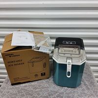 Full view of ice maker with box, paperwork and accessories.