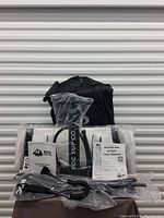 All components laid out: deflated board, paddle, pump, leash, repair kit, manual, and carry bag