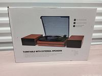 Box showing the turntable with two separate external speakers and some features.