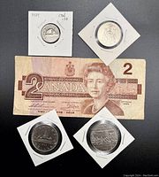 Complete view of the 1986 Canadian $2 bill and four Canadian coins in protective holders.