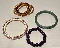Photo of five assorted costume bracelets showing various colors, styles, and materials.