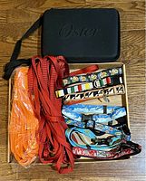 Overall view of the dog collars, leashes, and Oster grooming kit case on the floor showing contents of the lot