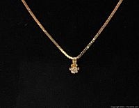 Necklace and pendant displayed against black background