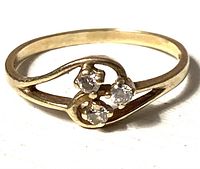 Front view of the 14k gold ring showing three small diamonds set in curved design.