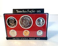 Front view of the plastic encased 1976-S US proof coin set produced in 1975, showing all six coins in red insert holder and black base labeled 'UNITED STATES PROOF SET'