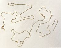 Three broken gold chains laid on white background