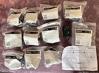 11 Invue PS18VUS 18V power supplies with US blades in plastic bags, one adapter out of bag, and printed instructions.