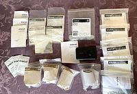 Multiple invue parts in bags and packets spread on a fabric surface showing the variety of model numbers and types