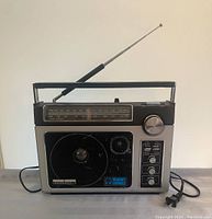 Full frontal view of the GE Superadio II showing the speaker grille, tuning knob, control switches and knobs, and extended telescoping antenna.