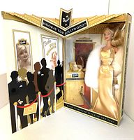 Front view of Barbie doll in original box with Hollywood premiere backdrop and keychain visible.