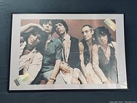 Framed poster showing front side with Rolling Stones group photo, includes visible ticket stubs in the frame corners.