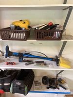 General overview of bike tools and accessories including blue floor pump, tool bag, and plastic baskets with smaller items.
