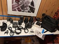 Overview of camera body with lenses, flash, charger, batteries, angle finder, case, manuals.