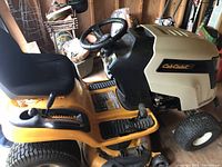 Side view of Cub Cadet riding mower showing seat, deck, and foot controls