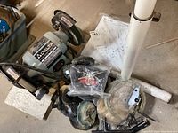 Delta Model 23-660 bench grinder with shielded grinding wheels and details of its label, alongside wire brush attachments and polishing wheels on a concrete floor.