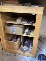 Wood pieces inside and on top of wooden cabinet including blocks, planks, and veneer pieces.