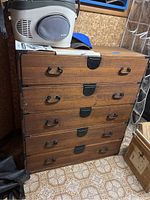 Front view of five-drawer chest showing drawer alignment and overall wear