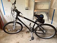 Side view of black Sedona Giant mountain bike showing the full frame, tires, pedals, saddle, and some accessories.