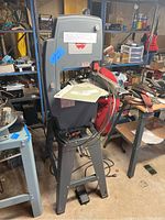 ShopSmith 11" bandsaw on stand in workshop with blades coiled around stand
