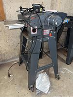 Planer unit mounted on motorized stand with cables and foot pedal visible