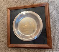 Frontal view of silver bowl in wooden frame