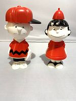 Photo of Charlie Brown and Lucy Avon shampoo figures side by side, showing full front view and general condition