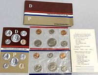 Two 1984 US uncirculated coin mint sets with original titled envelopes and informational documents. Coins are sealed in clear plastic holders.