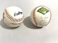 Two 1991 Rawlings baseballs shown side by side, one with the Oakland Athletics logo and multiple signatures, the other with official MLB marking and signatures.