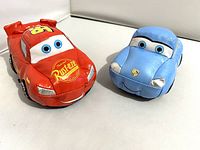 Lightning McQueen and Sally plush toys side by side, showing size and overall condition.