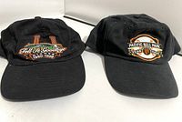 Front view of two black baseball caps showing embroidered logos for Candlestick Park and PacBell Park on the front