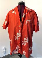 Front view of the vintage red Hawaiian shirt showing floral pattern, buttons, and pocket